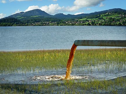 Pollution running out of pipe into lake