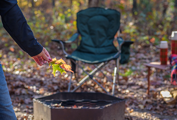 Camping in fall, woman holding leaf