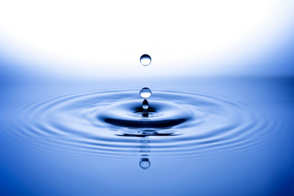blue drop of water and ripples fading to white in the background