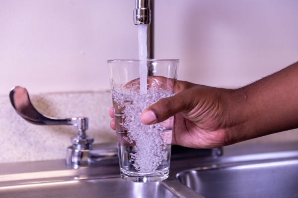 photo of someone filling a glass with tap water 