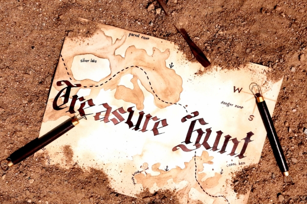 photo of a treasure map labeled "Treasure Hunt" laying  on the soil