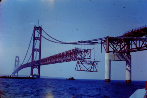 photo of bridge by All Things Michigan CC-BY-NC-2.0 via Flickr photo of bridge under construction as large section in put in place by cranes
