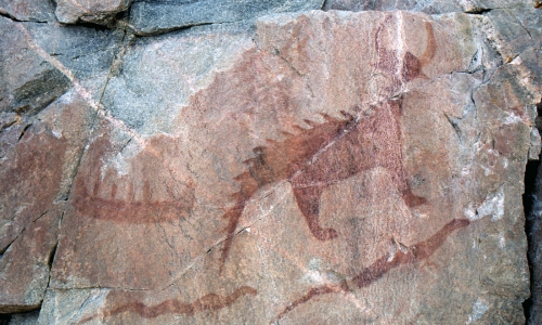 photo by Giorgio Galeotti (CC BY-SA 3.0) photo showing figures drawn in red on rock