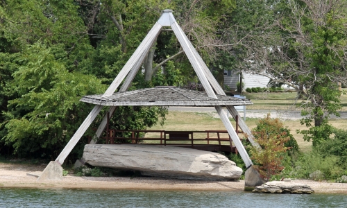 photo by LeeG7144 (CC BY SA 3.0) A pyramid structure with a viewing platform protects a rock with inscriptions