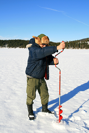 Man using ice auger Man using ice auger