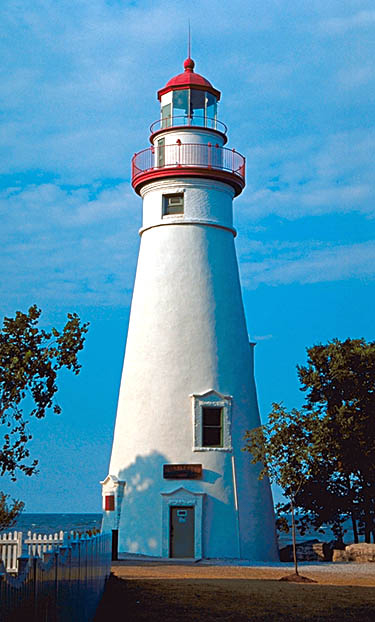 Marblehead Lighthouse at the entrance to Sandusky Bay White lighthouse, with red roof. Lake Erie in the background.
